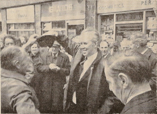 Out of the hat.- The draw for ringing order took place outside the Church of St. Vedast and a representative of the West Down team is seen “taking his pick” whilst fellow members and competitors look on and officials jot down the order.
